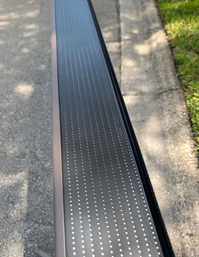 Lengthwise view of a perforated gutter guard on a section awaiting installation.