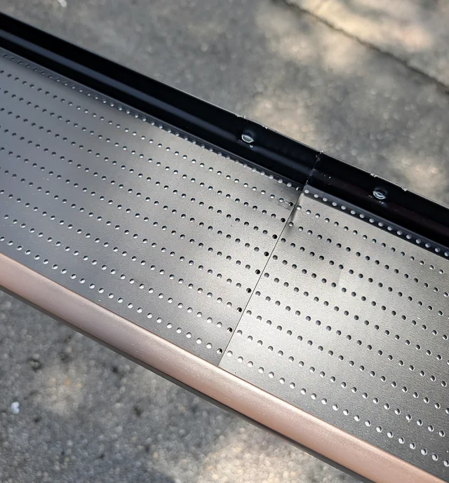 Close-up of an adjoining gutter-guard section joint and fasteners during assembly.